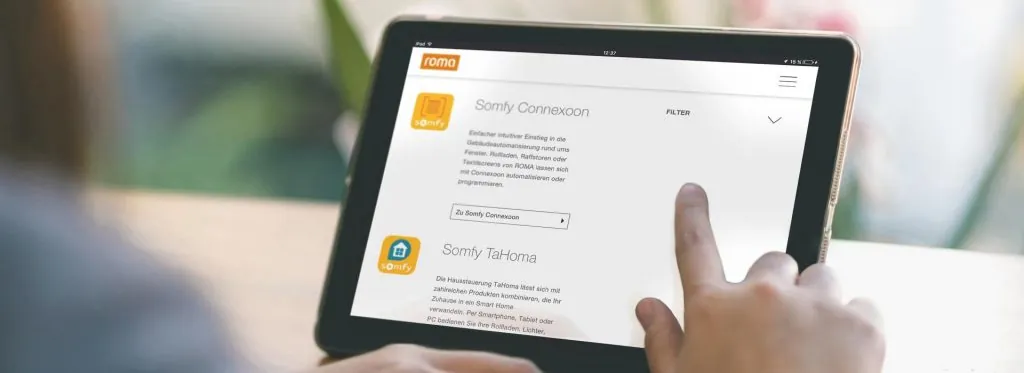 Hand bedient die ROMA Smart-Home-App auf einem Tablet